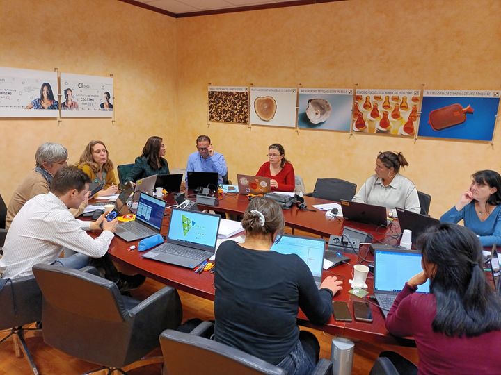 grupo de trabajo reunido en una mesa redonda con ordenadores