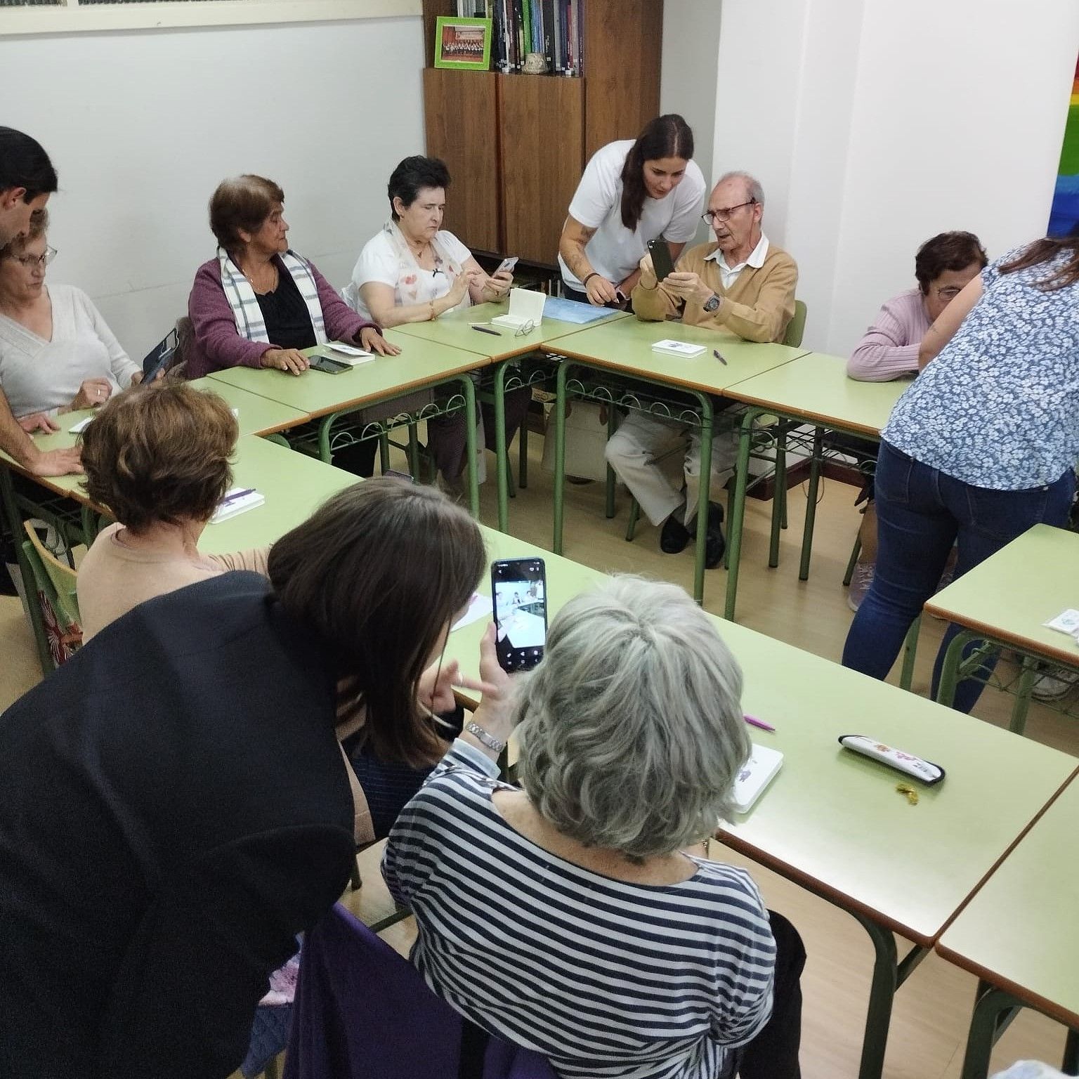 Foto del grupo formativo con jóvenes y mayores trabajando conjuntamente y sus smartphones.