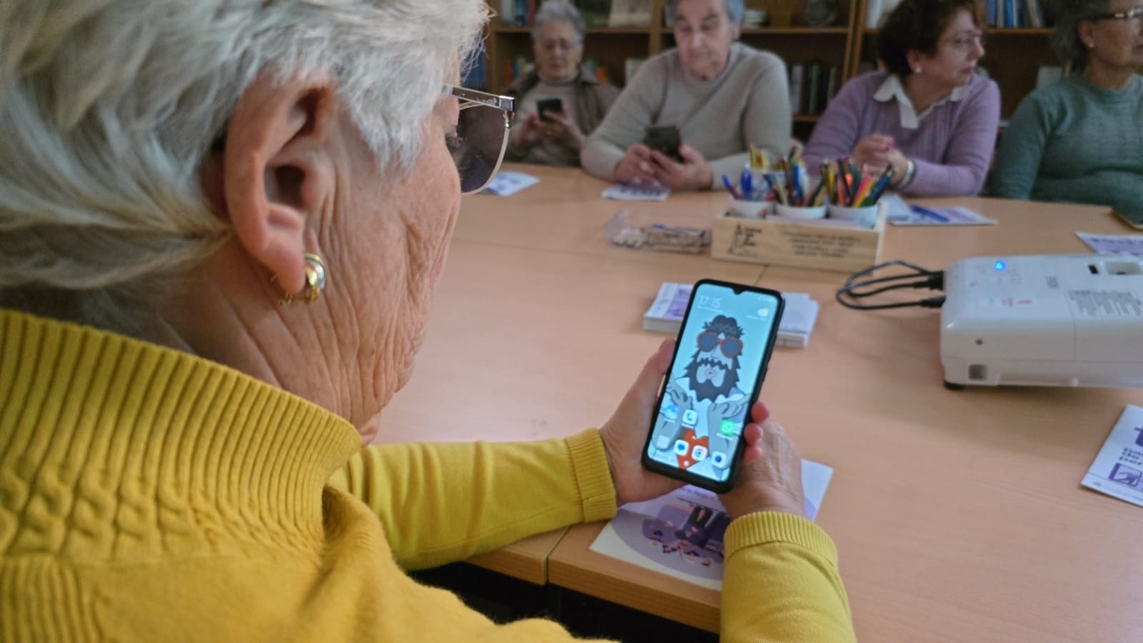 Una señora con su teléfono móvil en primer plano.