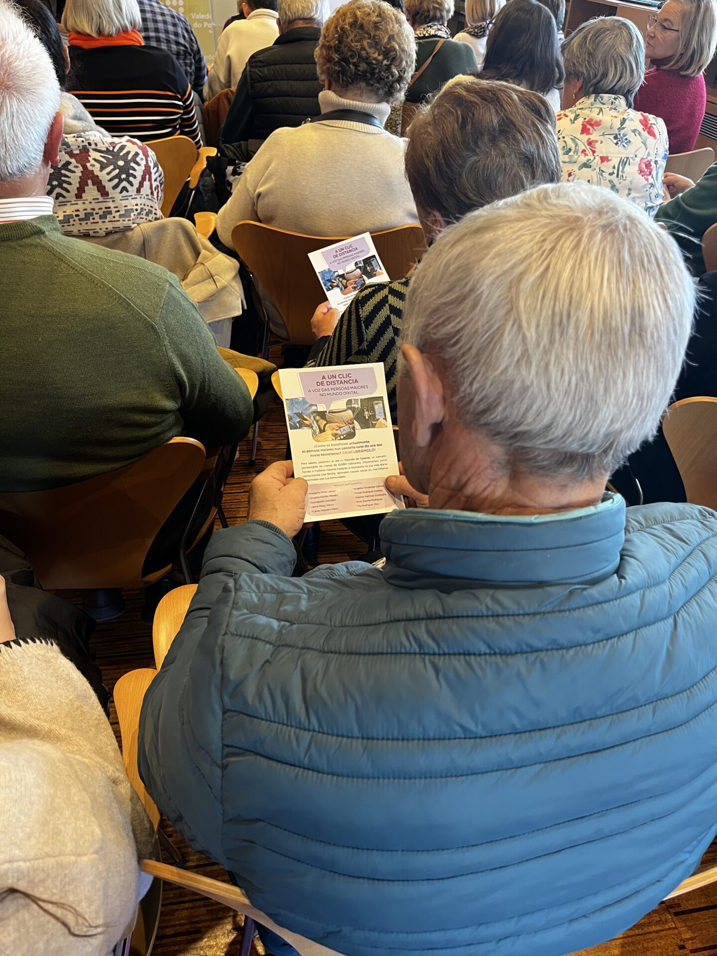 Persona mayor leyendo el flyer donde se explica el contenido y motivación de la exposición